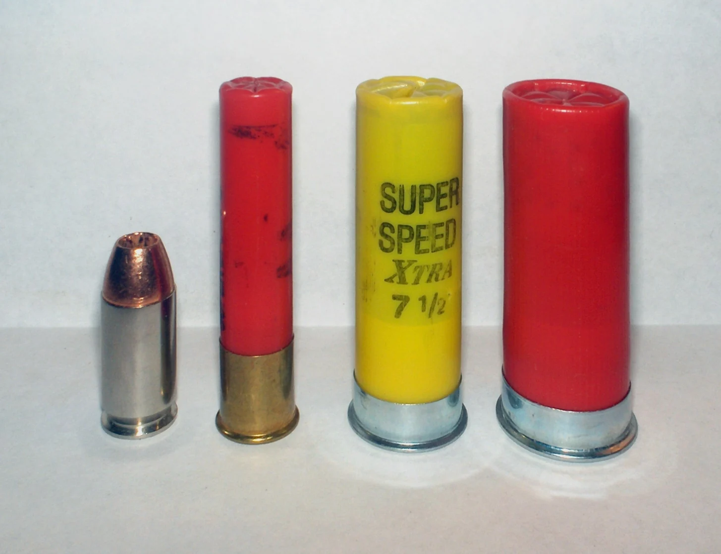Four cartridges side by side: a .45 Auto pistol round, a .410 bore shell, a 20 gauge shell and a 12 gauge shell