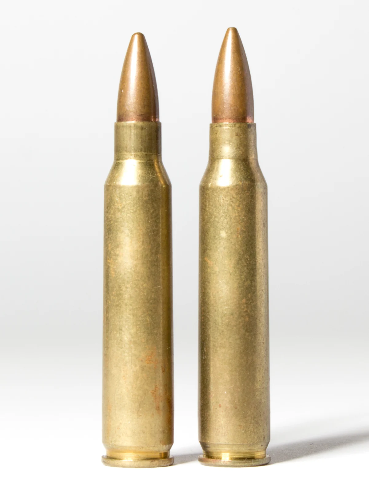A .223 Remington cartridge photographed beside a 5.56x45mm NATO cartridge for comparison