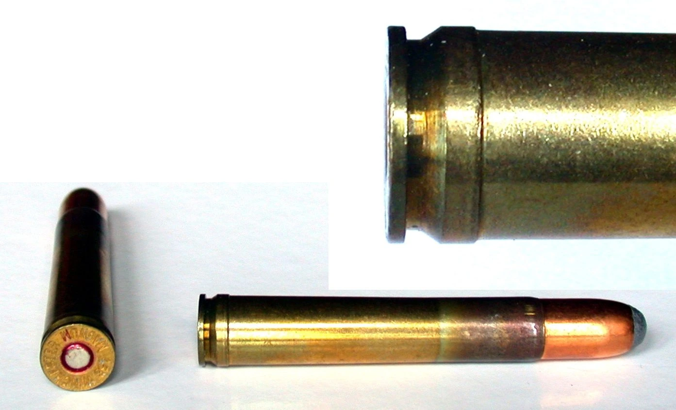 A brass .458 Winchester Magnum cartridge shown from the side and from the base, its base showing the raised belt just above the extraction groove.