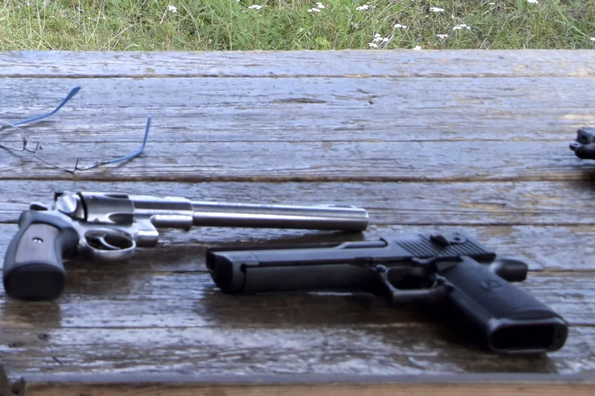 A large stainless-steel Desert Eagle semi-automatic pistol lying on a wooden table