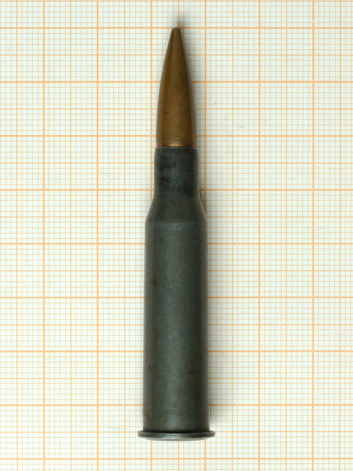 A 7.62x54mmR cartridge photographed upright, its rim visible at the base
