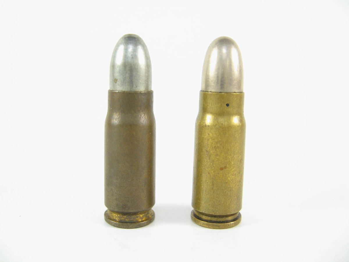 Two similar bottleneck cartridges with rounded bullets standing side by side, a darker-cased one on the left and a brighter brass one on the right with small crimp marks near its case mouth.