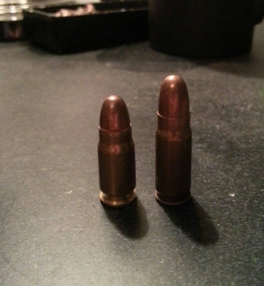 Two similar bottleneck pistol cartridges standing upright side by side, the left one slightly shorter than the right.