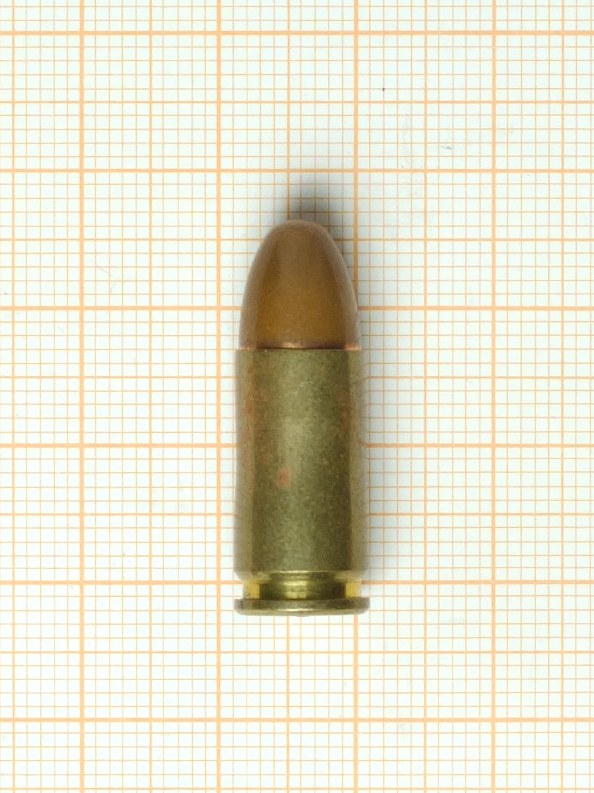 A single 9x19mm Parabellum cartridge photographed upright against a plain background