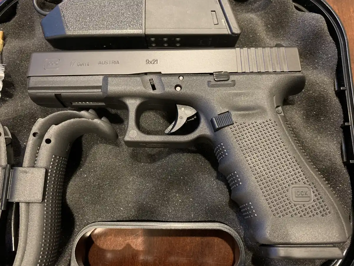 Close-up of the slide of a black polymer-framed pistol resting in a foam-lined case. The slide is engraved GLOCK, 17 Gen4, AUSTRIA, and 9x21.