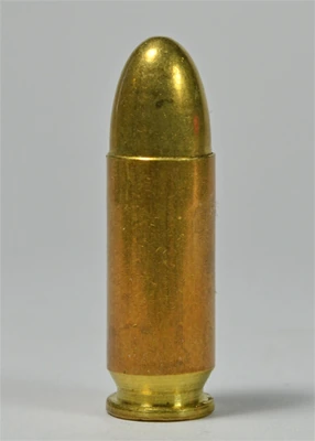 A 9×23mm Largo pistol cartridge standing upright, a round-nose full metal jacket bullet seated in a long, gently tapered brass case.