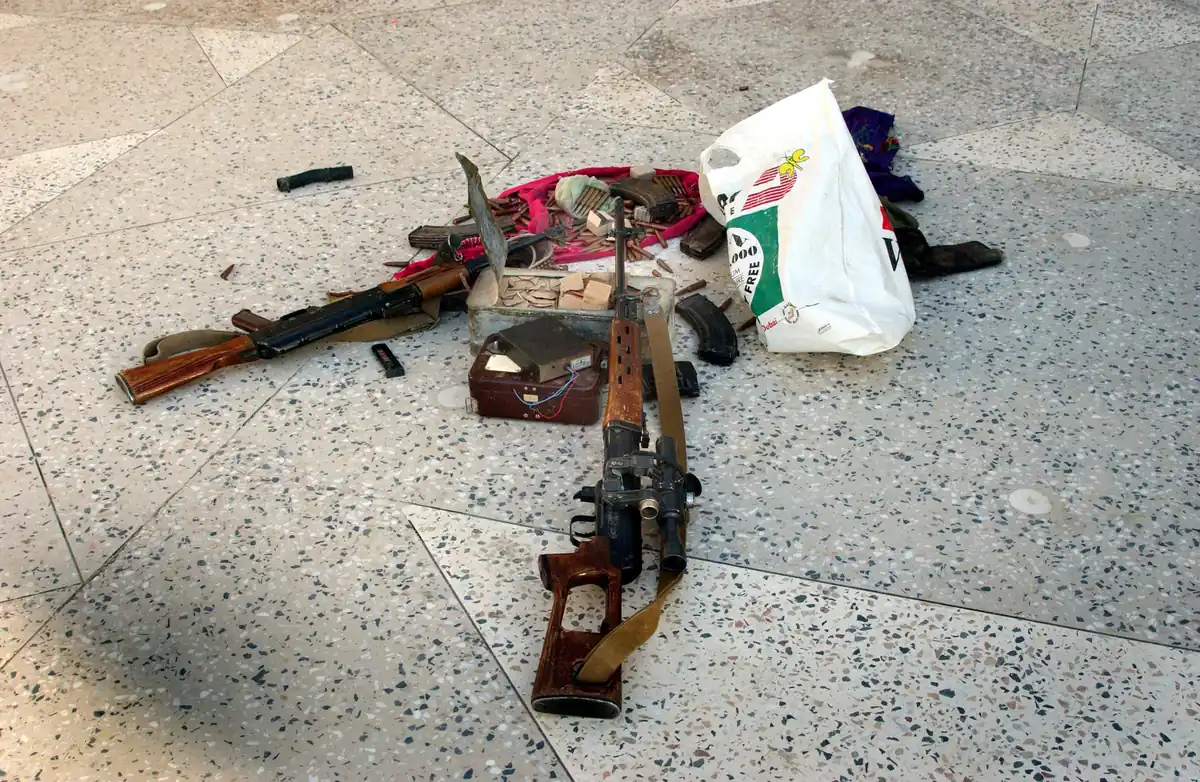 Rifles and ammunition laid out on the ground after being captured