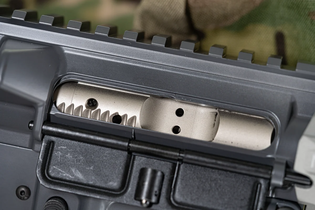 An AR-15 bolt carrier group removed from the rifle and photographed on a plain surface