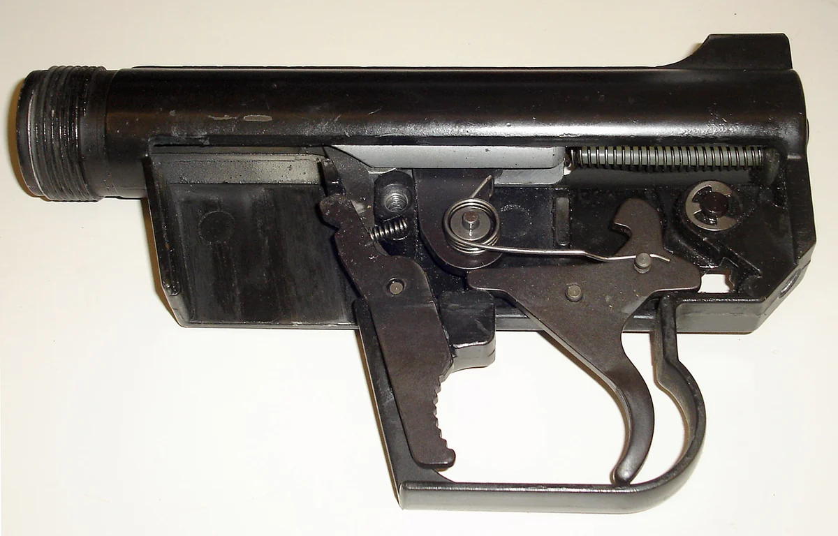 The AR-7's receiver with its left sideplate removed, showing the bolt and trigger mechanism