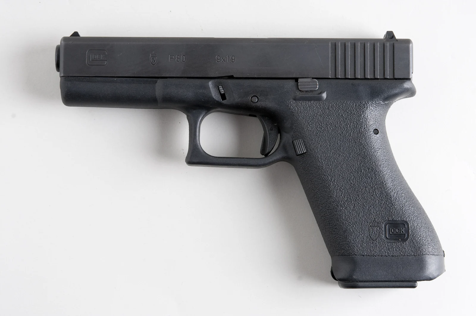 A Glock 17 pistol photographed from the right side on a plain surface