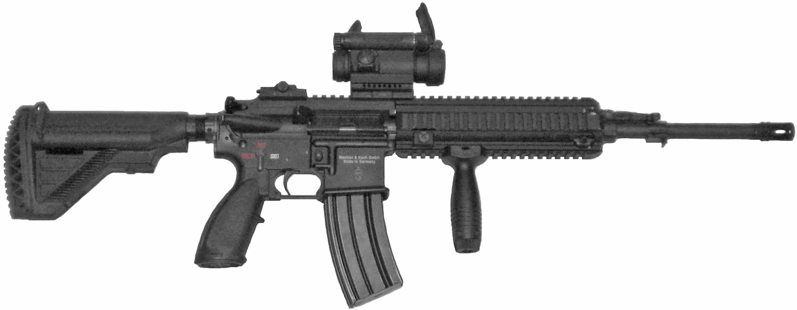 An HK416 rifle isolated on white, seen from the left, with a collapsible stock, a red-dot sight and a vertical foregrip on a railed handguard, and a curved 30-round magazine