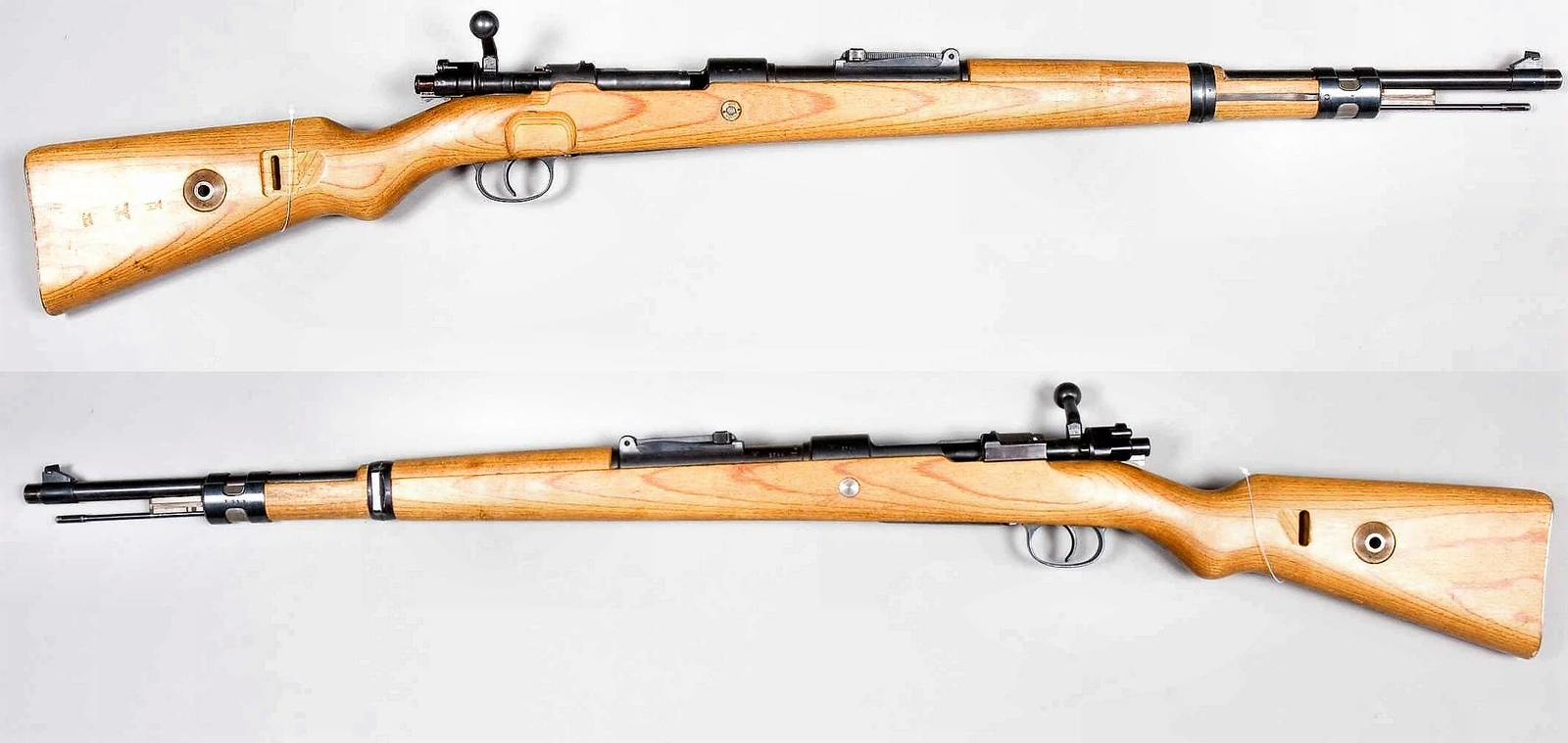 Two views of a Karabiner 98k rifle on a white background, left and right sides, with a pale wooden stock, a bolt handle turned down against the receiver and a ladder rear sight