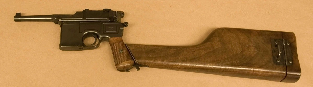 A Mauser C96 pistol with a wooden shoulder stock fitted to the rear of its grip, turning it into a short carbine-like weapon