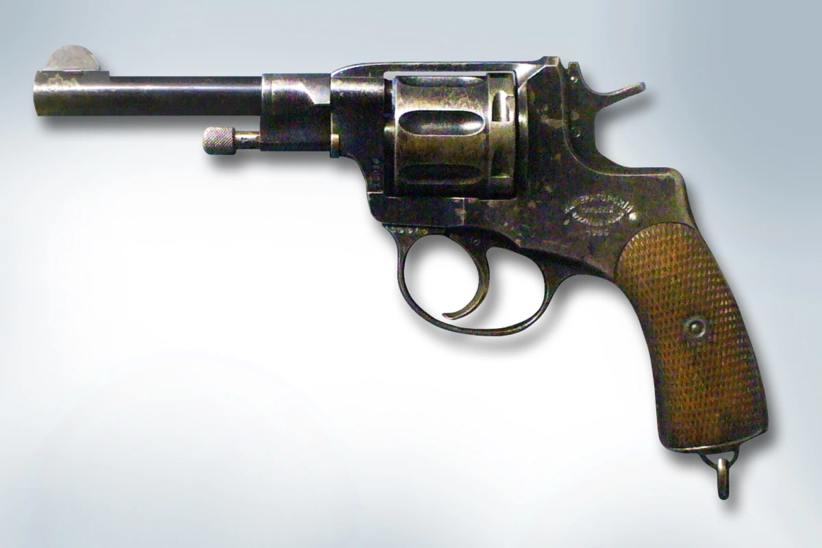 A small revolver with a checkered wooden grip, an octagonal-topped barrel and an enclosed cylinder, shown against a plain background.