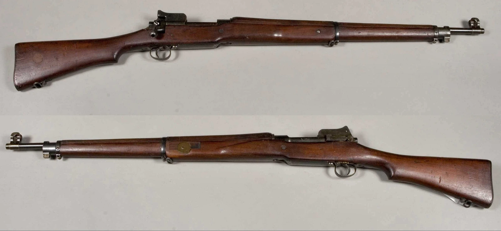 A long bolt-action rifle with a wooden stock running nearly the full length of the barrel, an aperture sight behind the receiver and a bayonet lug at the muzzle.