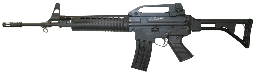 A Pindad SS2-V1 assault rifle in right side profile: a black rifle with a carrying handle over the receiver, ribbed handguard, side-folding stock extended, and a curved STANAG magazine