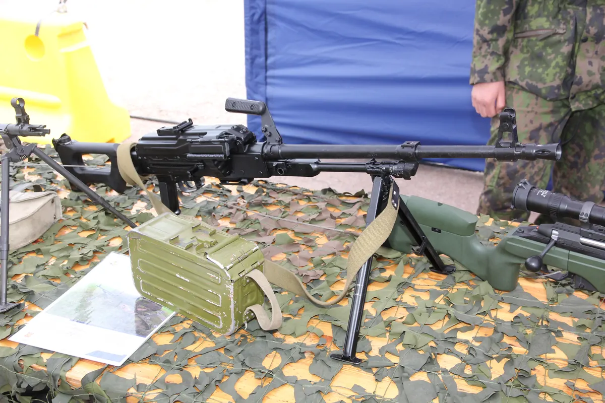 A PKM machine gun with a 100-round ammunition box displayed in a museum