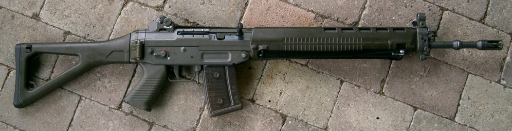 A green SIG SG 550 rifle with a folding metal wire stock, ribbed handguard and a translucent curved box magazine, seen from the left