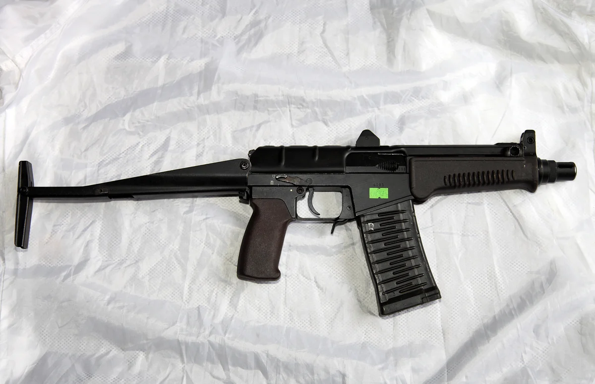 The same carbine with its skeletal buttstock unfolded and extended to the rear, shown on a plain white background.