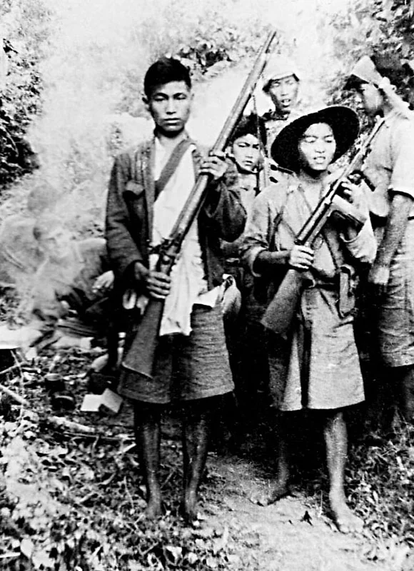 Two young Kachin scouts in wartime Burma, one holding an M42 submachine gun