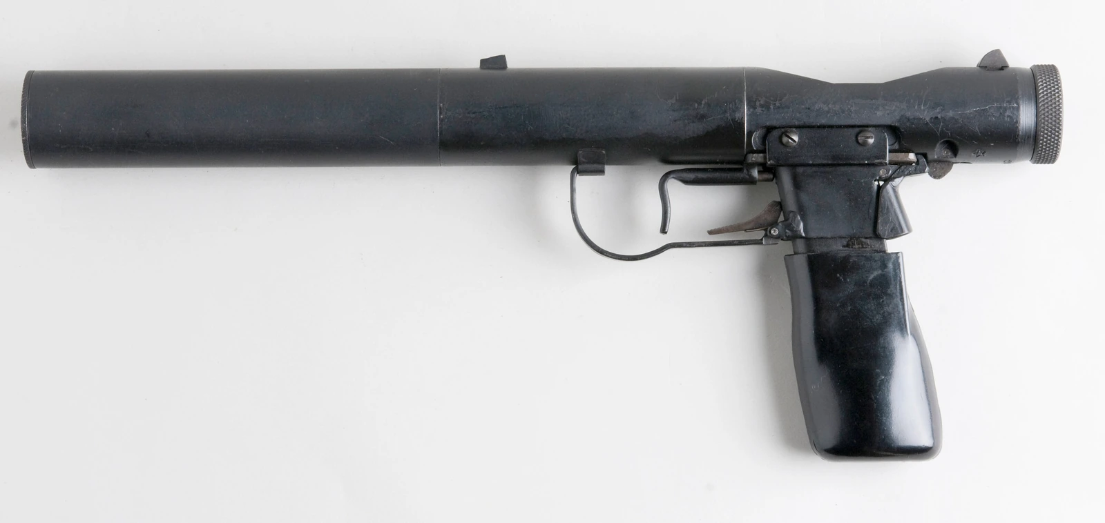 A plain metal cylinder pistol with a small pistol grip magazine and a knurled bolt knob at the rear