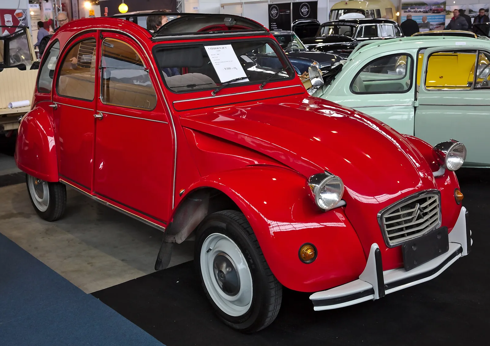 Grey Citroën 2CV photographed from the front three-quarter angle, showing the corrugated bonnet, round headlamps and rolled canvas roof