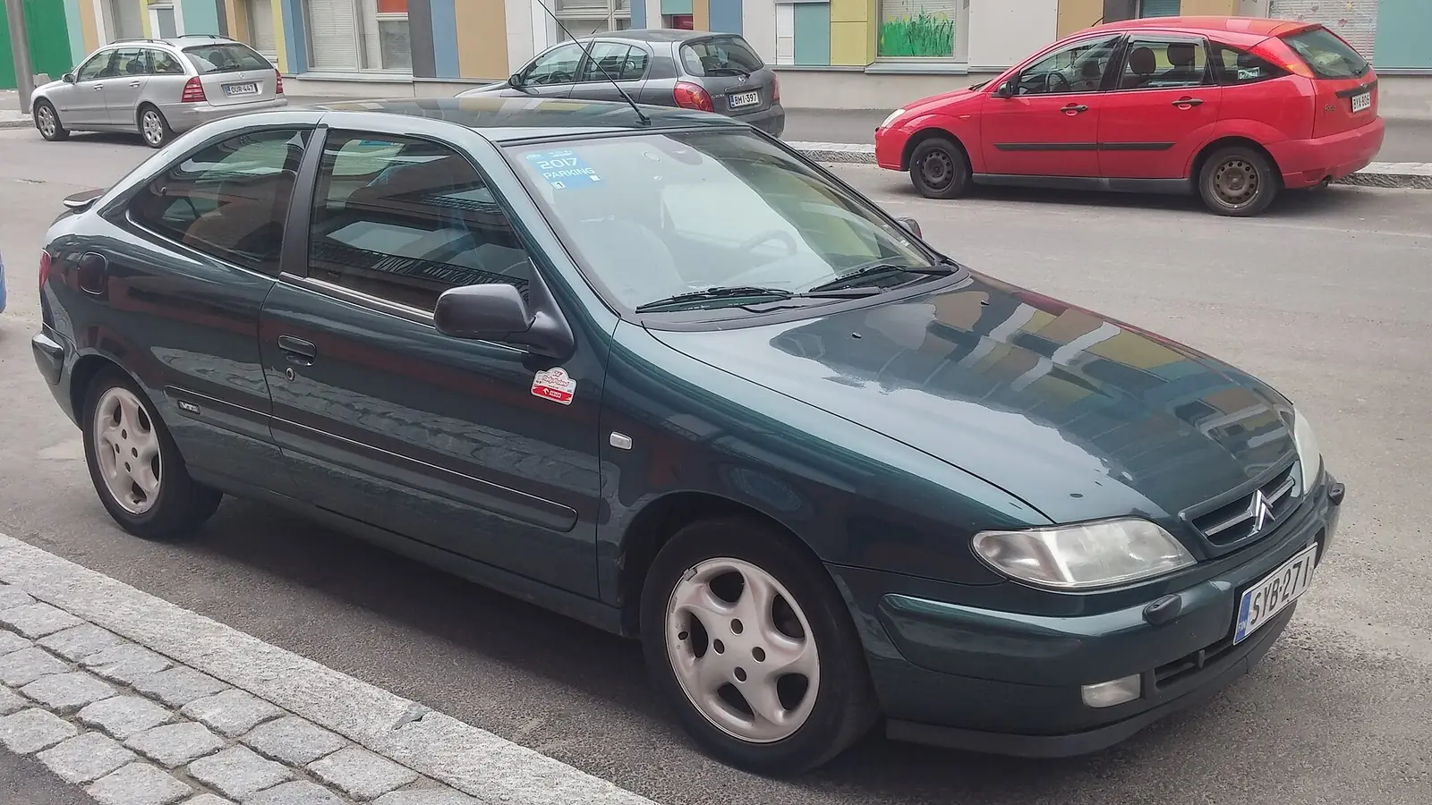 Dark green pre-facelift Citroën Xsara hatchback photographed from the front three-quarter angle