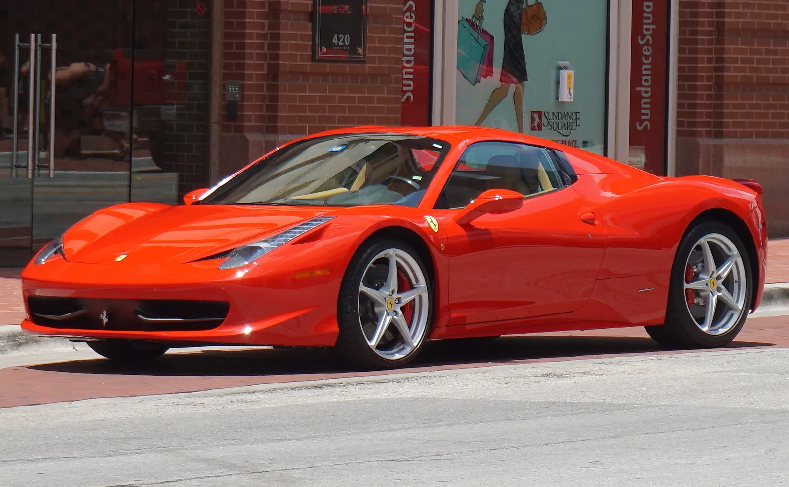 Orange Ferrari 458 Italia coupé photographed from the front three-quarter angle