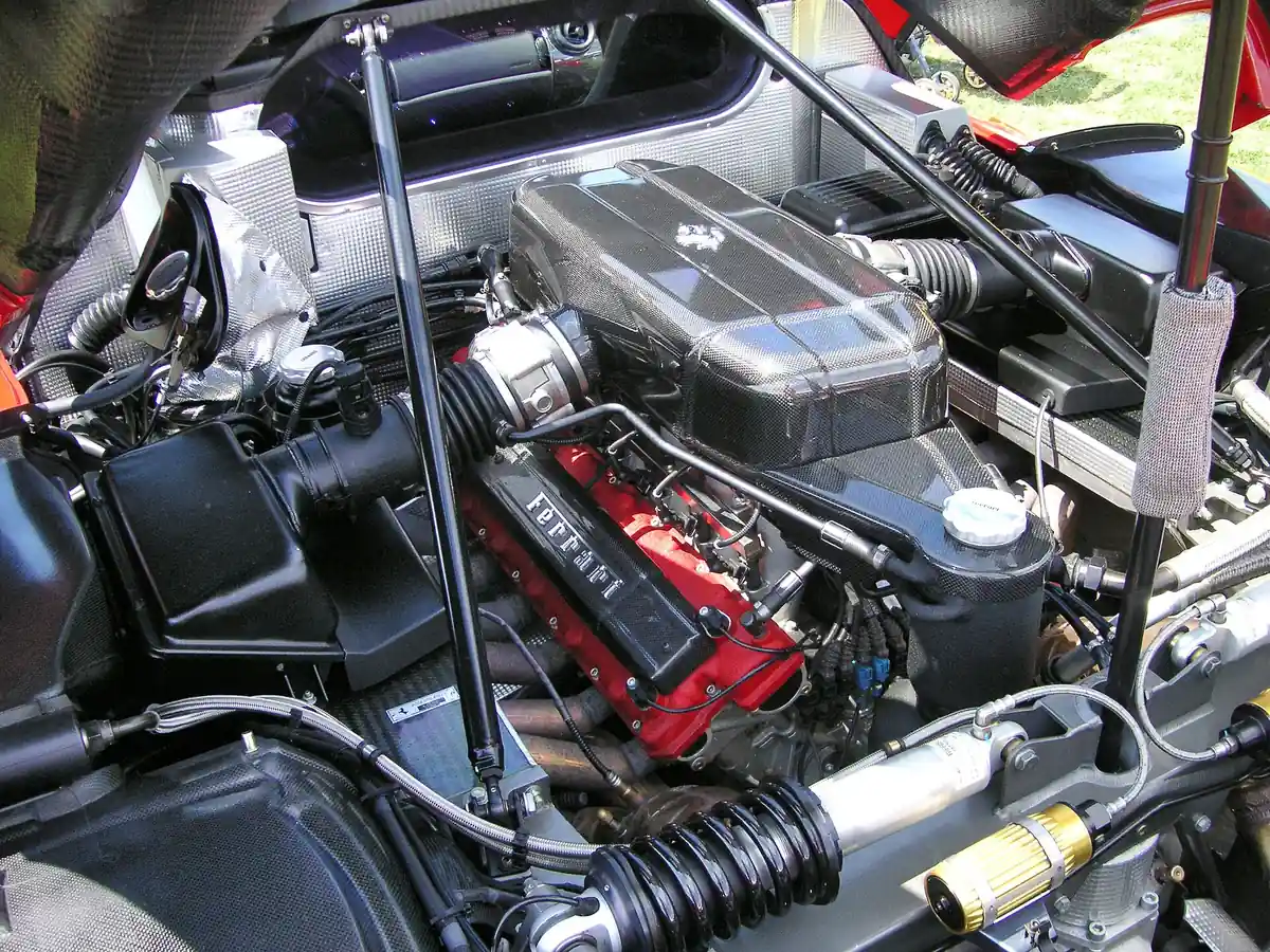 Ferrari Enzo engine bay showing the naturally aspirated V12 with its intake plenums and red cam covers