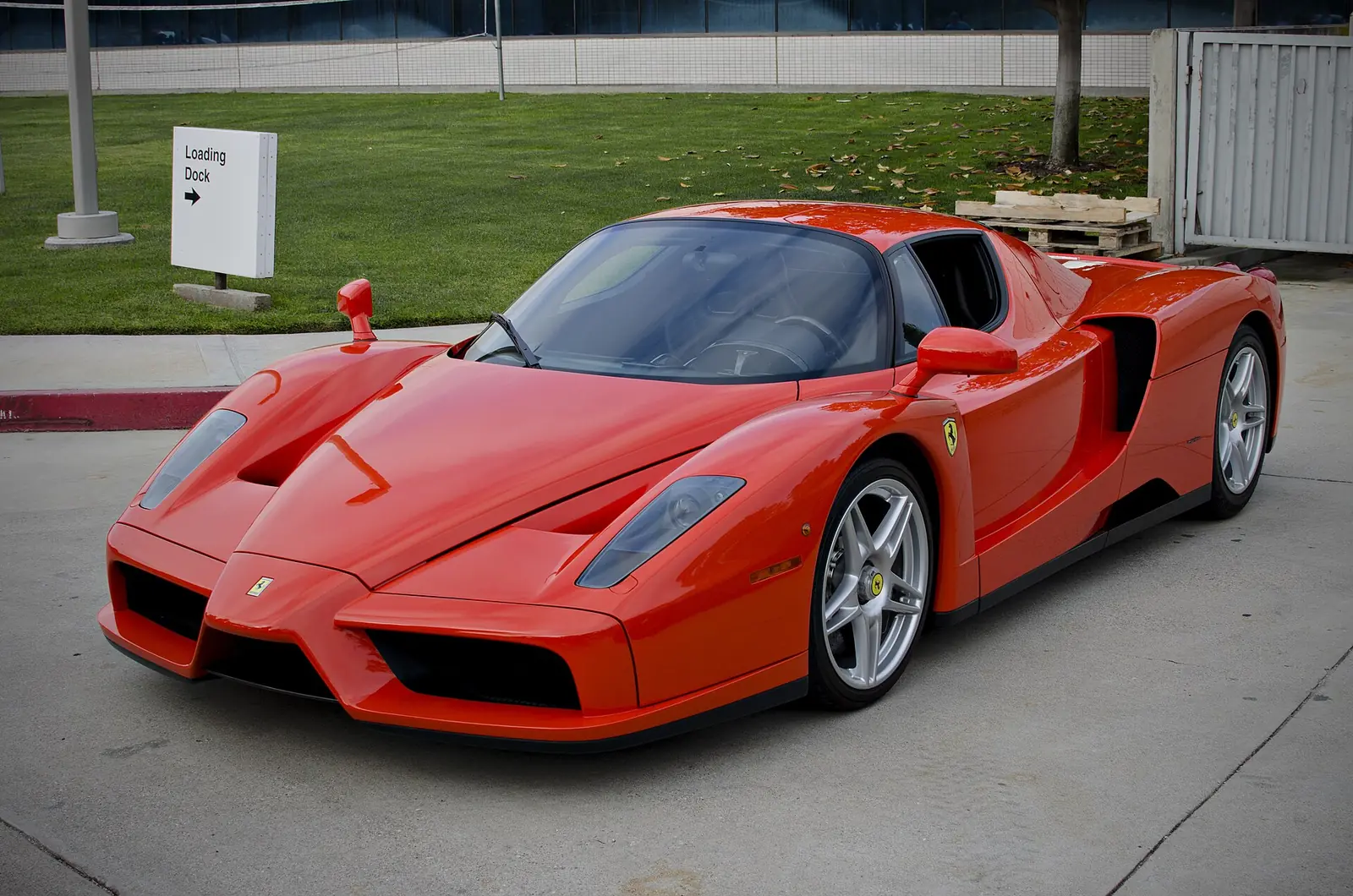 Red Ferrari Enzo photographed from the front three-quarter angle, showing its Formula One-influenced nose and butterfly doors