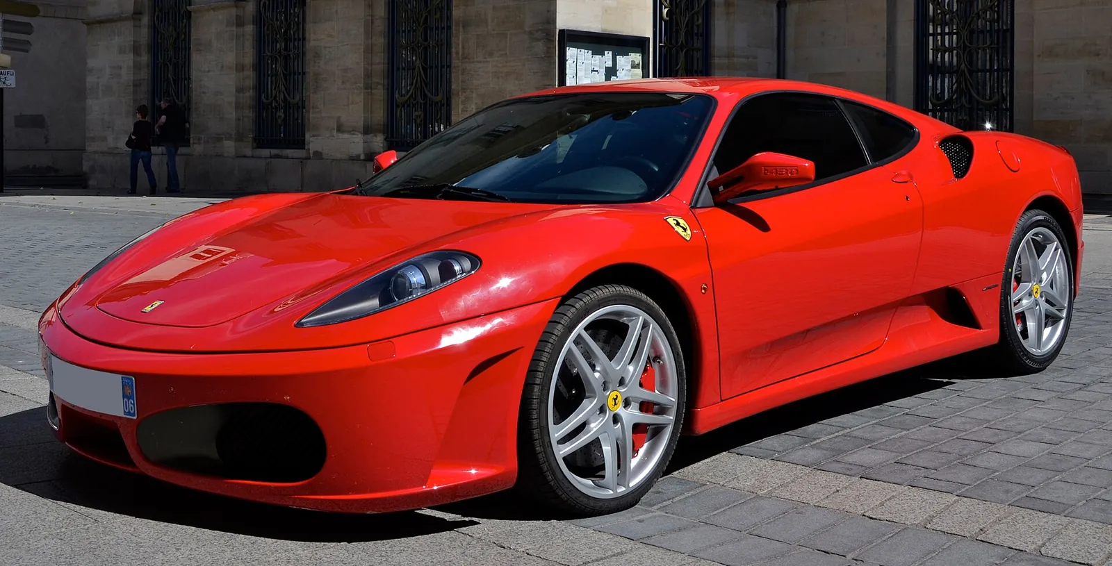Red Ferrari F430 coupé photographed from the front three-quarter angle