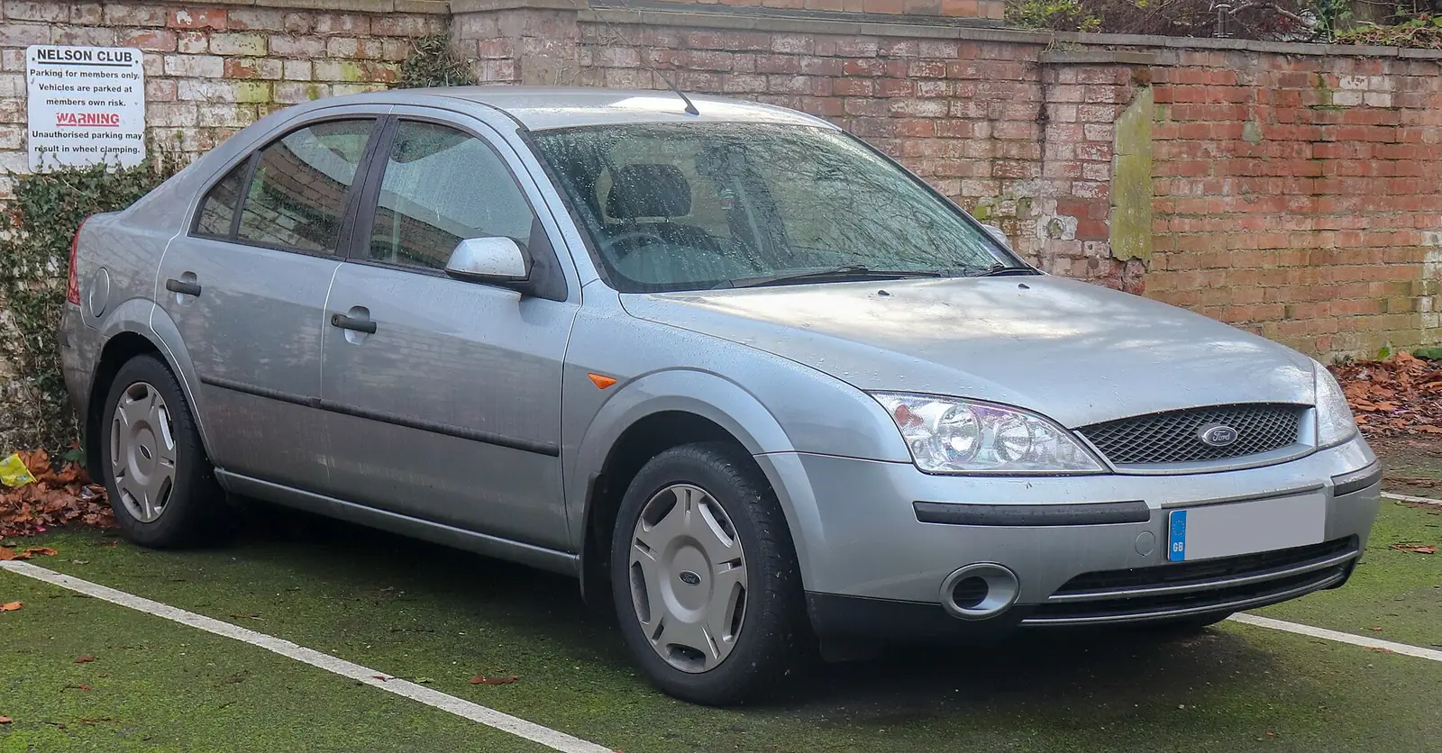 Silver second-generation Ford Mondeo saloon photographed from the front three-quarter angle beside a brick wall