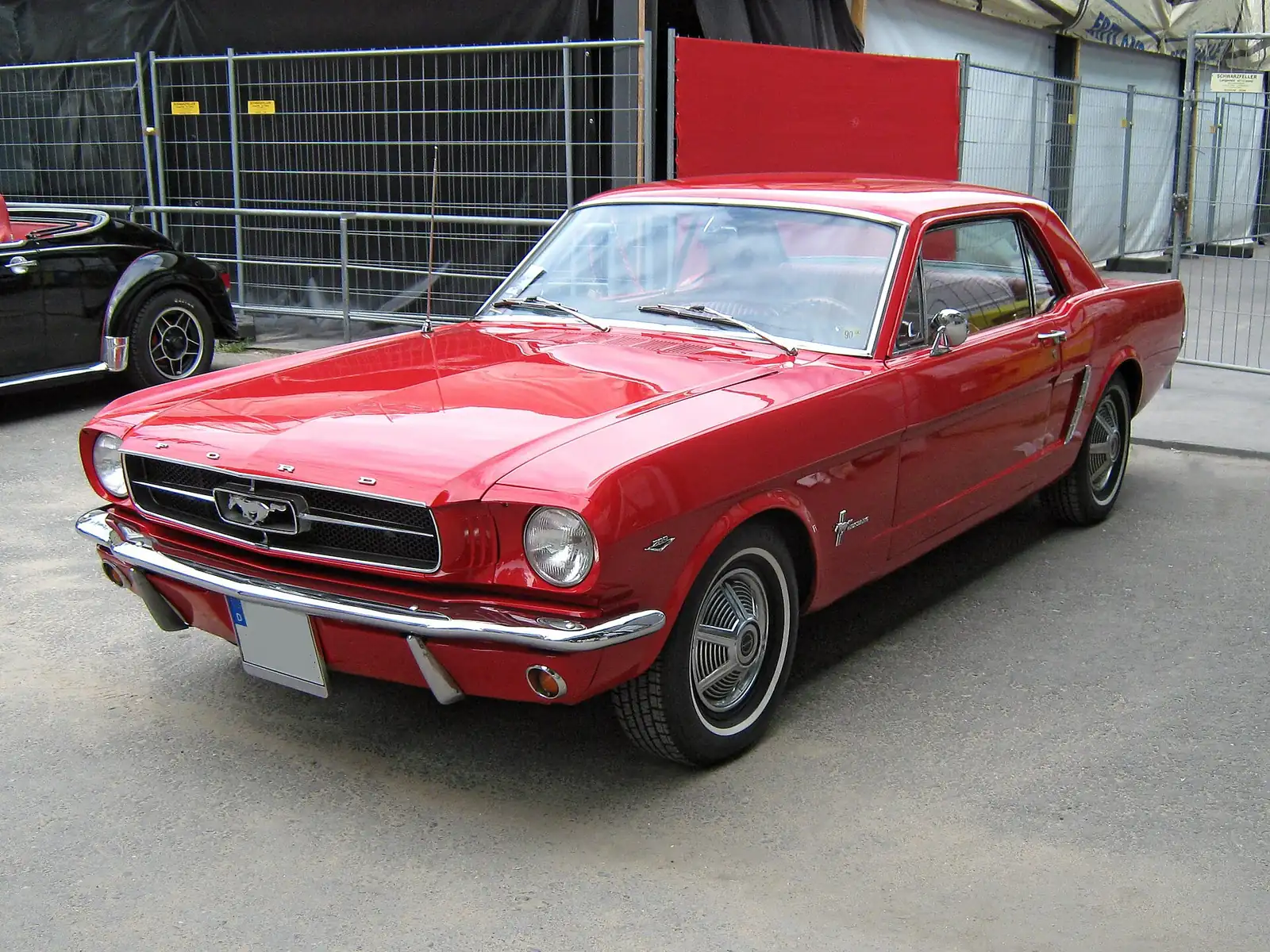 Red 1965 Ford Mustang two-door hardtop photographed from the front three-quarter angle