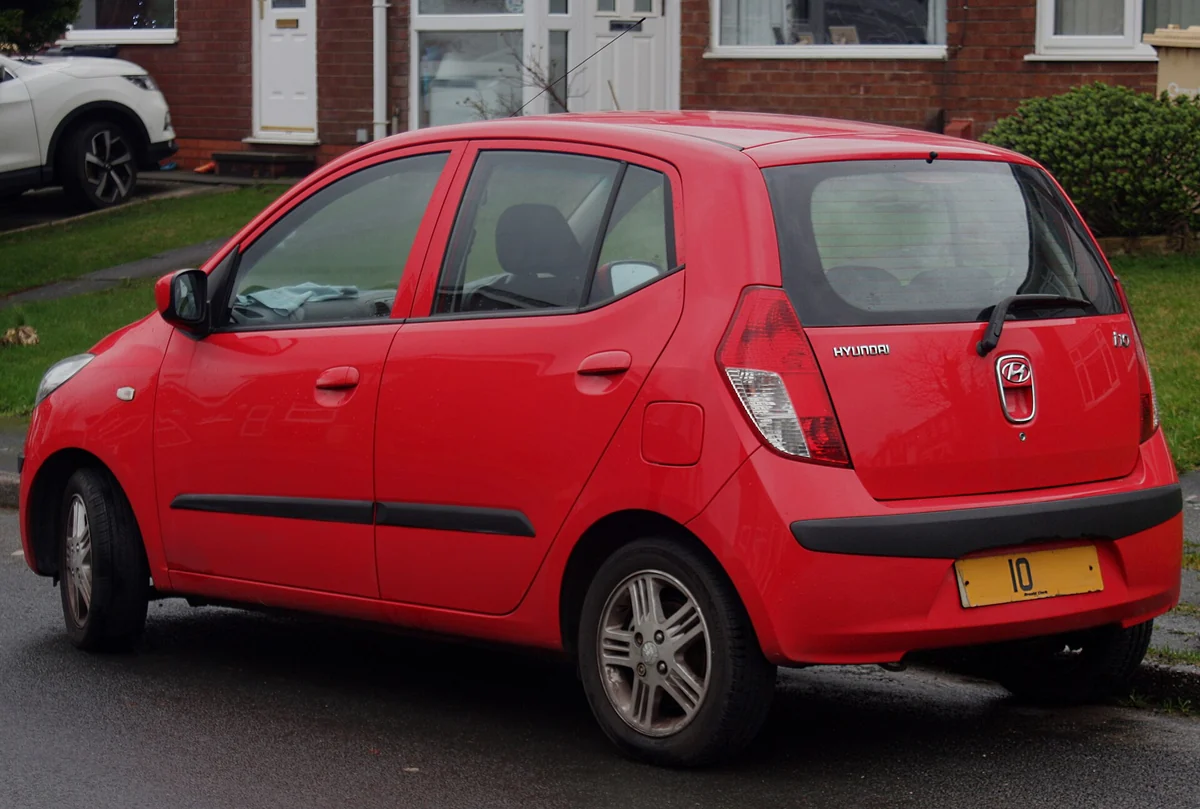 Rear three-quarter view of a red first-generation Hyundai i10 hatchback