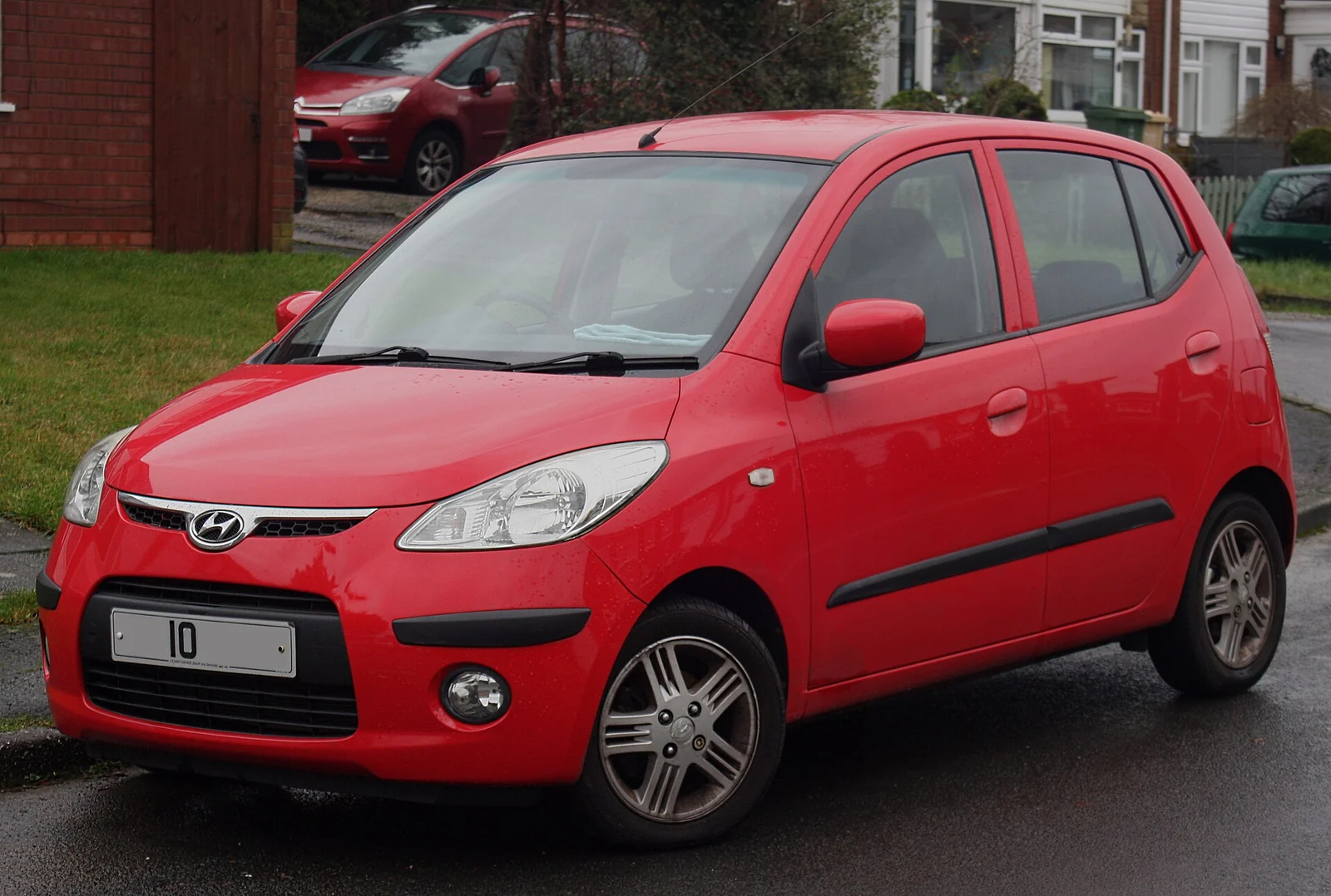 Red first-generation Hyundai i10 five-door hatchback photographed from the front three-quarter angle