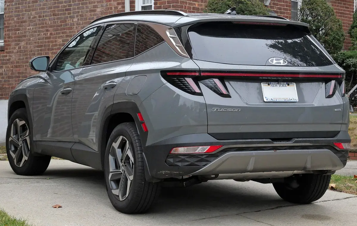 Rear three-quarter view of a grey long-wheelbase Hyundai Tucson Limited, showing the connected LED tail light bar