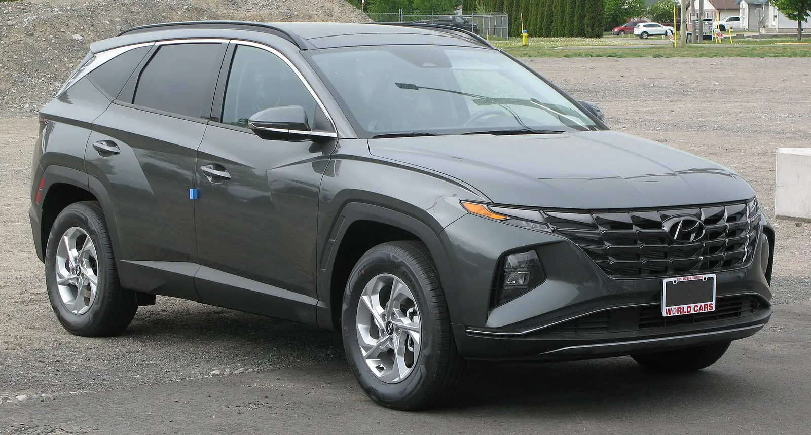 Dark grey fourth-generation Hyundai Tucson photographed from the front three-quarter angle, showing its angular jewel-like grille and geometric daytime running lights
