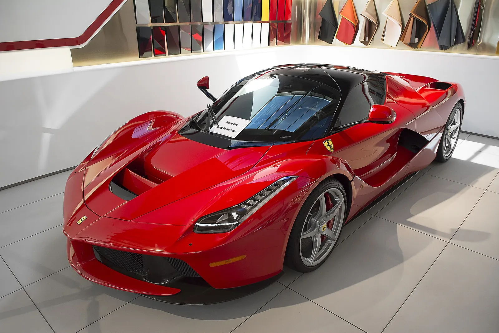 Red LaFerrari coupé photographed from the front three-quarter angle, showing its low nose and butterfly door