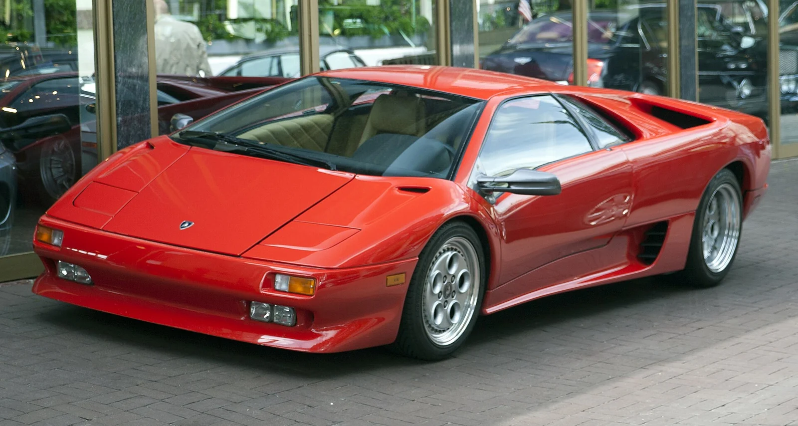 Red Lamborghini Diablo with pop-up headlamps raised, photographed from the front three-quarter angle
