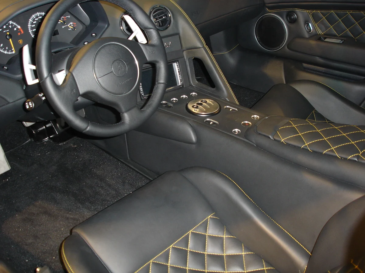 Interior of a Lamborghini Murciélago LP640 showing the steering wheel, quilted leather seats and centre console with the e-gear paddle