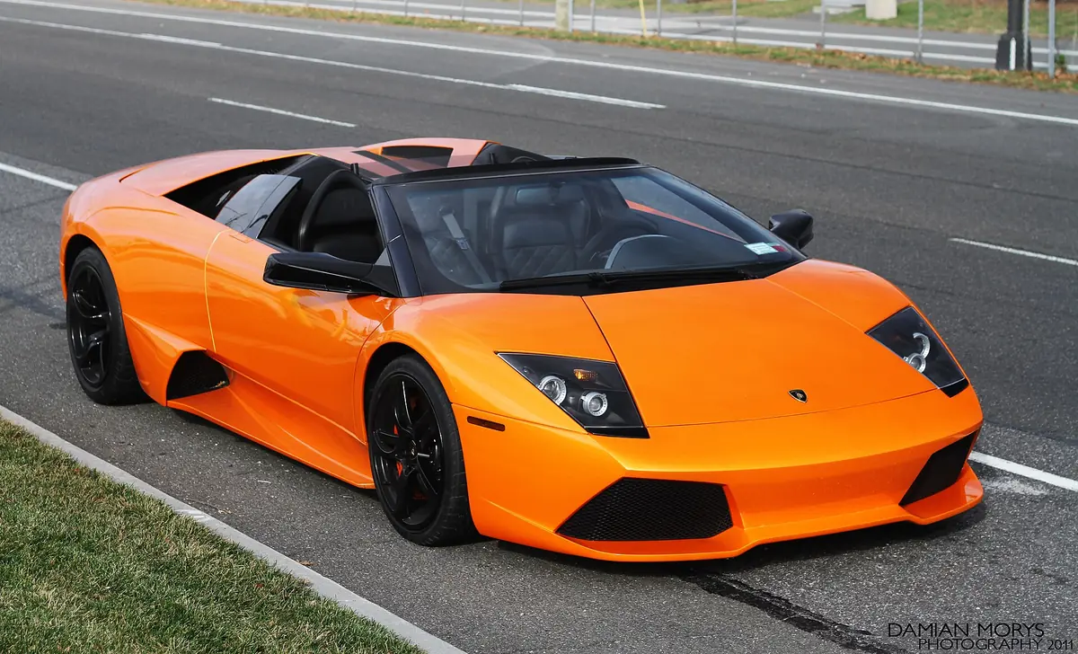 Orange Lamborghini Murciélago LP640 Roadster with its fabric roof removed, parked at the roadside