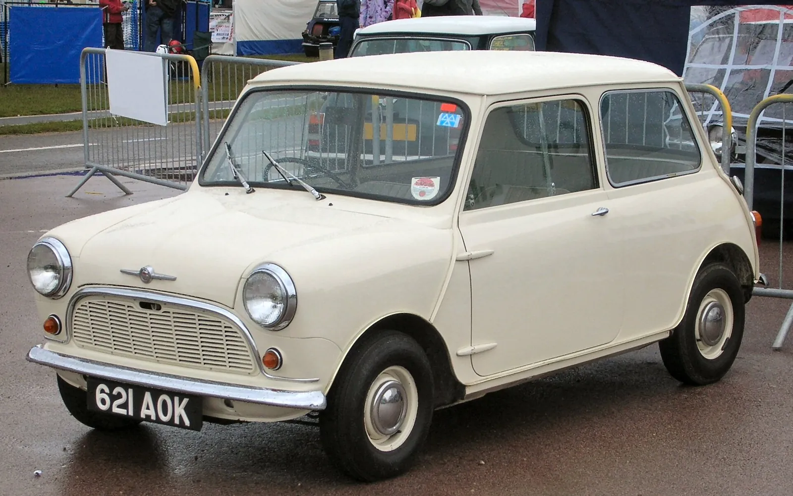 Cream-coloured 1959 Morris Mini-Minor photographed from the front three-quarter angle, showing the round headlamps, full-width front grille and registration plate 621 AOK