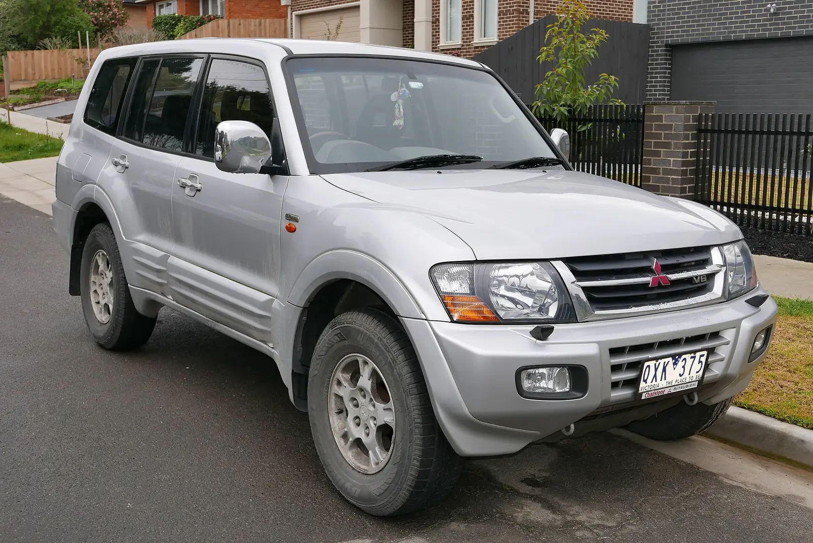 Silver third-generation Mitsubishi Pajero Exceed five-door SUV photographed from the front three-quarter angle on a residential street