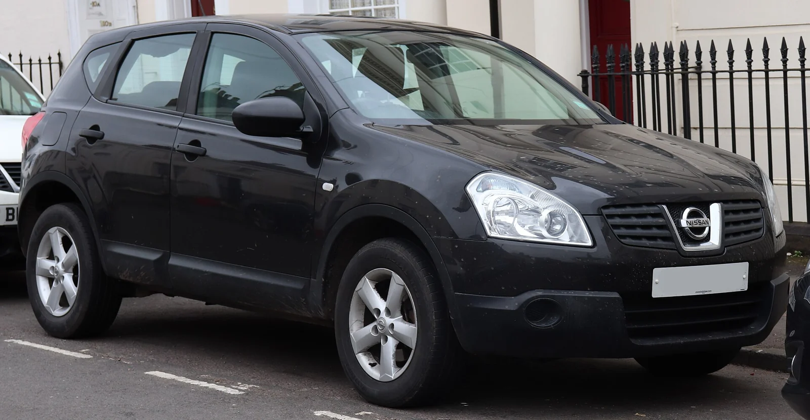 Black first-generation Nissan Qashqai photographed from the front three-quarter angle, showing its rounded crossover body and high beltline