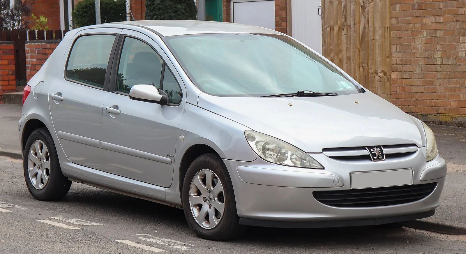 Silver five-door Peugeot 307 hatchback photographed from the front three-quarter angle on a residential street