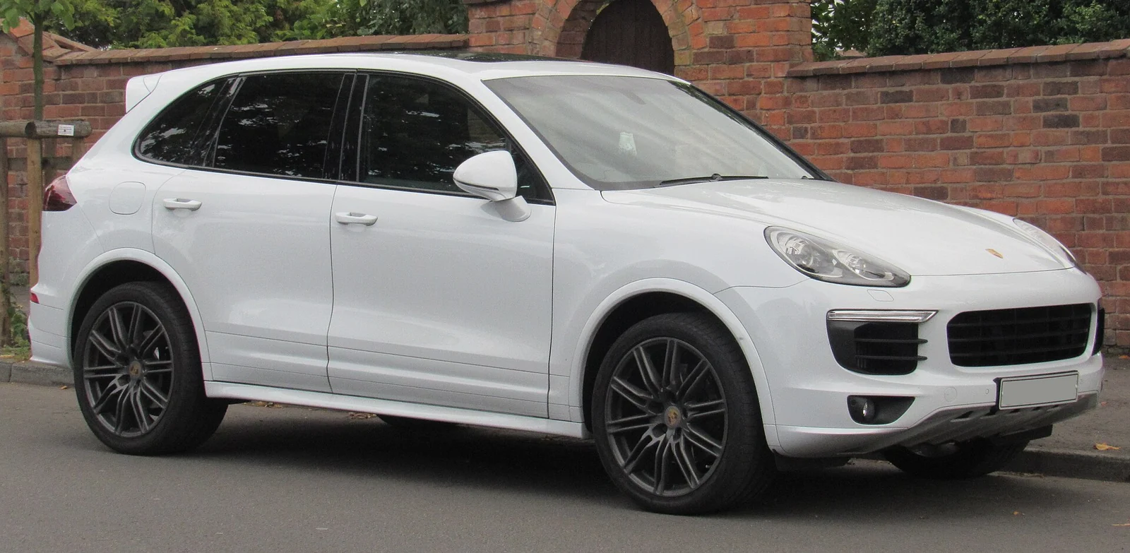 White second-generation Porsche Cayenne Diesel SUV photographed from the front three-quarter angle on a residential street