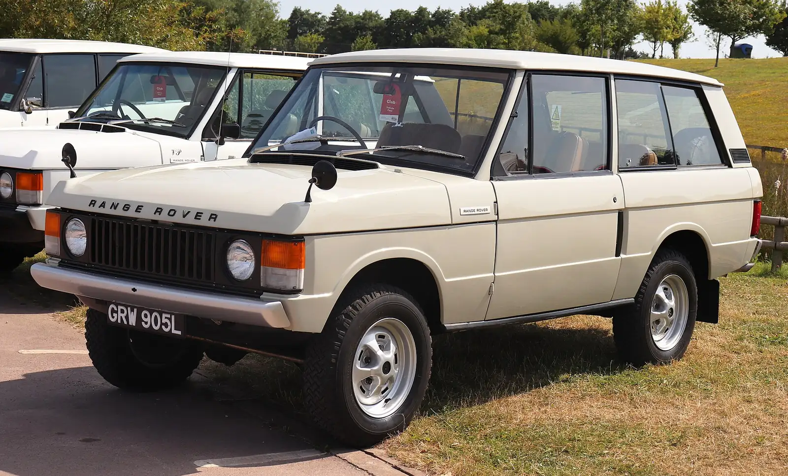 Blue 1973 Range Rover photographed from the front three-quarter angle, showing the two-door body, flat glass and castellated bonnet line