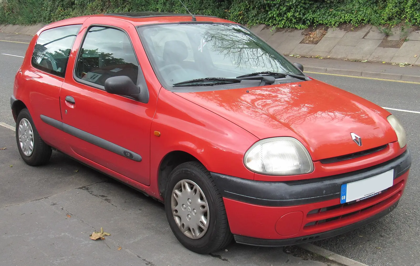 Red pre-facelift second-generation Renault Clio hatchback, photographed from the front three-quarter angle