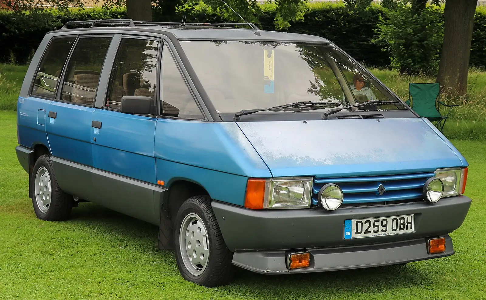 Blue and grey two-tone first-generation Renault Espace parked on grass, photographed from the front three-quarter angle