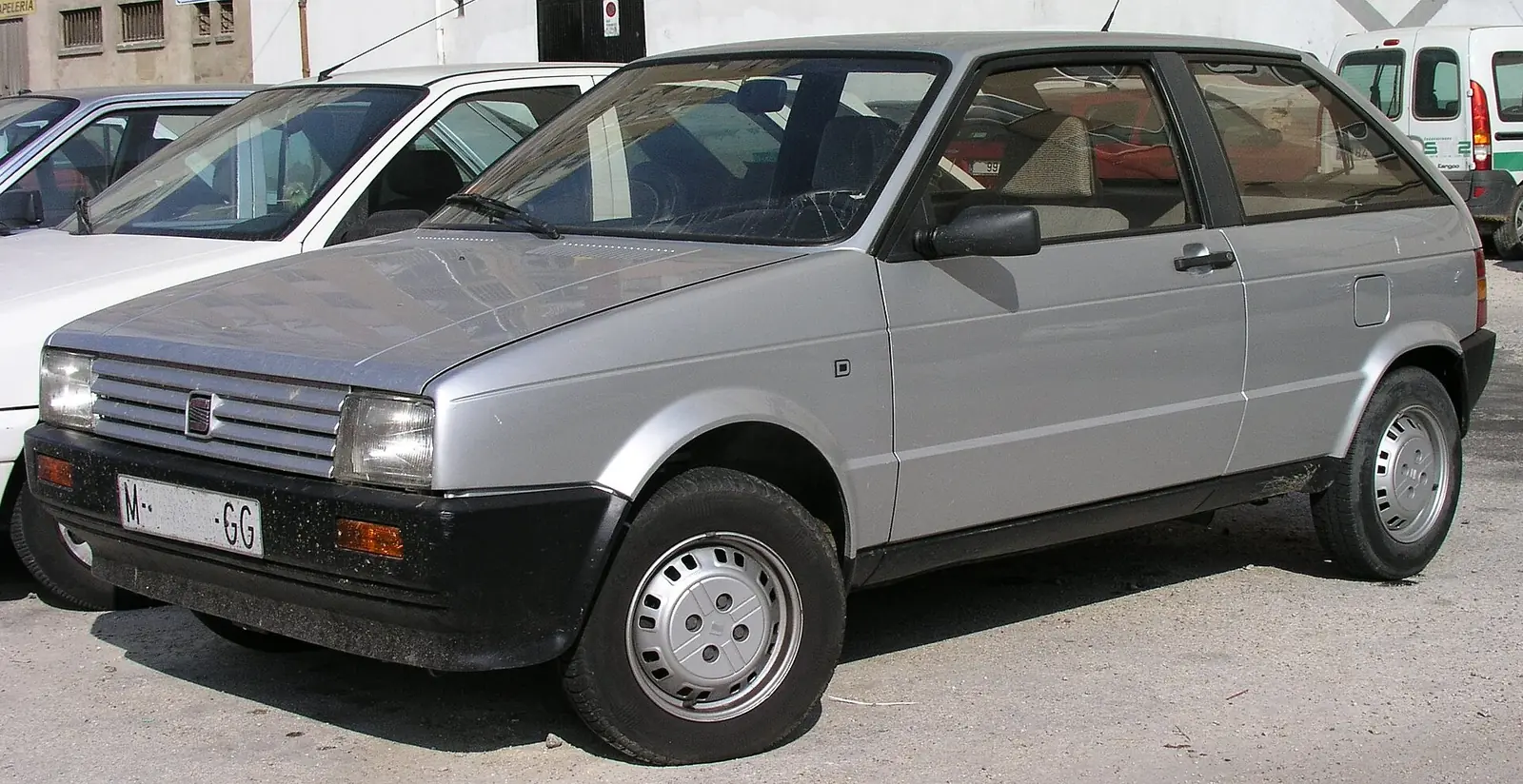 Silver first-generation SEAT Ibiza three-door hatchback photographed from the front three-quarter angle, parked among other cars